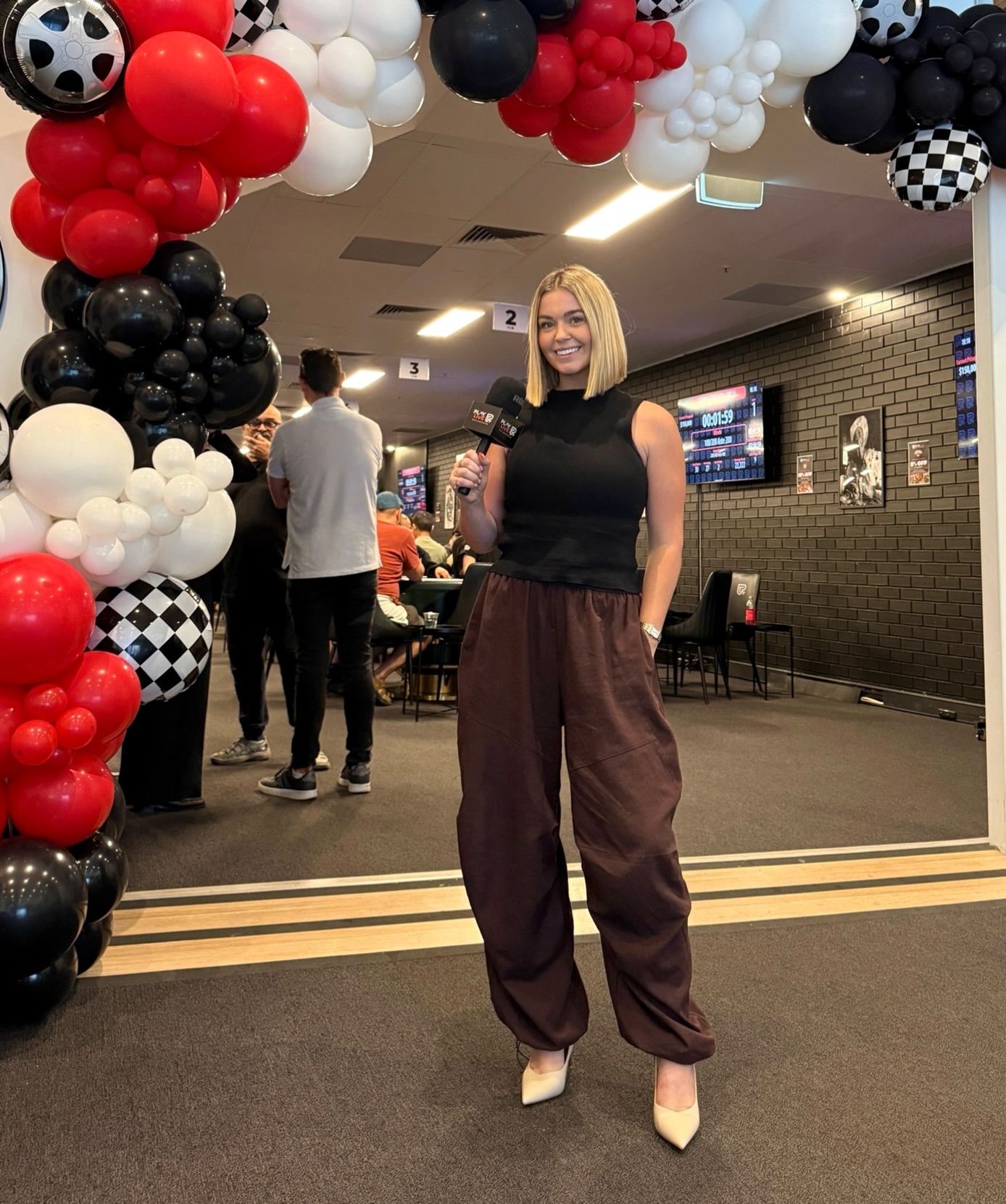 Teri hosting a live tournament event with a microphone